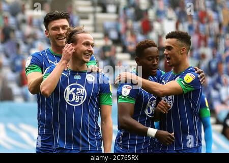 Kieran Dowell di Wigan Athletic (seconda a sinistra) celebra il terzo gol del gioco con Kieffer Moore (a sinistra) Antonee Robinson (a destra) e Jamal Lowe durante la partita del campionato Sky Bet allo stadio DW di Wigan. Foto Stock