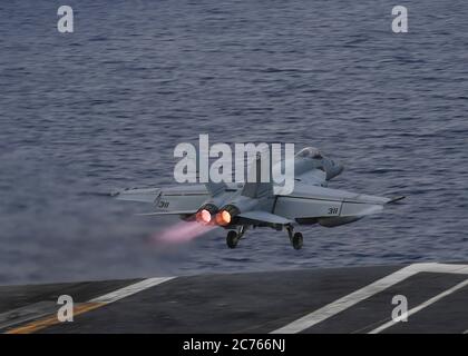 Un US Navy F/A-18E Super Hornet assegnato ai Kestrels of Strike Fighter Squadron 137, durante la manutenzione di routine a bordo della portaerei di classe Nimitz USS Nimitz durante le operazioni a doppio vettore con la USS Ronald Reagan 28 giugno 2020 nel Mare delle Filippine. Foto Stock