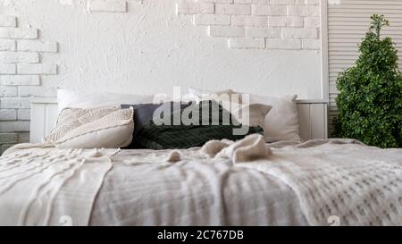 Letto non fatto in camera moderna. Da sopra calda coperta e morbidi cuscini collocati su comodi letti non fatti in elegante camera da letto contemporanea Foto Stock