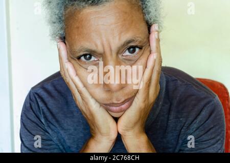 Donna con le mani sulle mascelle Foto Stock