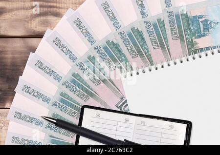1000 russo rubli ventilatore e blocco note con libro di contatto e penna nera. Concetto di pianificazione finanziaria e strategia aziendale. Contabilità e investimenti Foto Stock