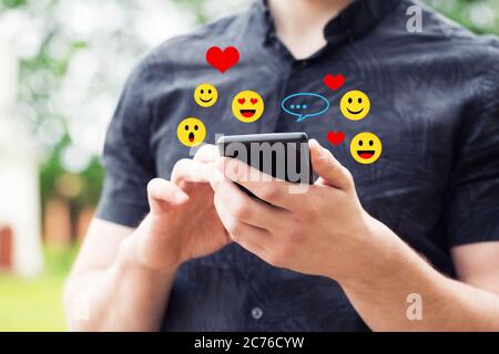 Uomo che usa lo smartphone mobile, primo piano. Giovane uomo che tiene uno smartphone mobile. Foto Stock