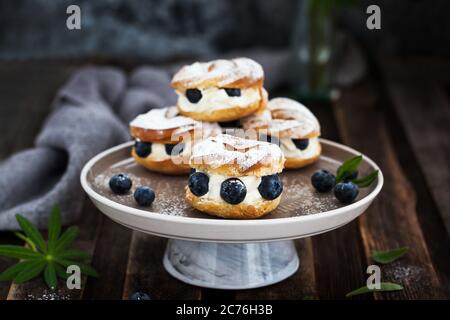 Anelli di sfoglia (pasta choux) decorati con mirtilli freschi Foto Stock