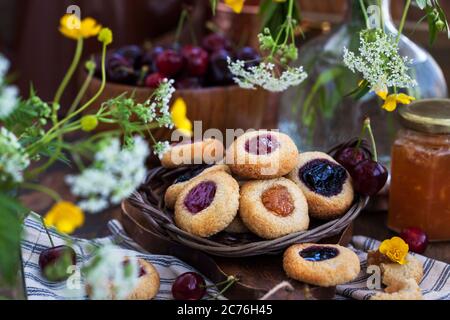 Biscotti di mandorle con marmellata su rustico sfondo di legno Foto Stock