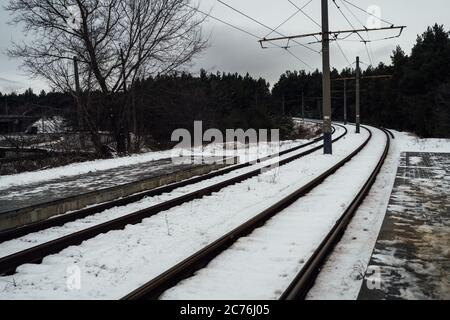 Treno in inverno. Splendido paesaggio di campagna. Binario ferroviario posato attraverso la foresta. Foto Stock