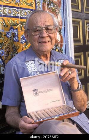 Cigar Maker tiene il suo Cigar arrotolato a mano davanti al Columbia Restaurant, Ybor City, Tampa, FL, USA Foto Stock