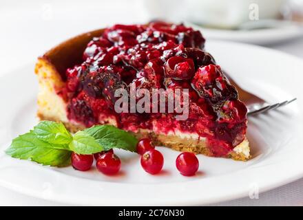 Frutti di bosco torta con verde menta sulla piastra con la forcella. Messa a fuoco selettiva Foto Stock