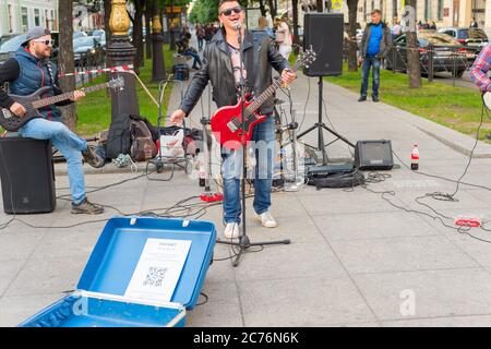 SAN PIETROBURGO, RUSSIA - 11 LUGLIO 2019: I musicisti si esibiscono in una strada di San Pietroburgo. Putin ritratto su un t-short di un cantante Foto Stock