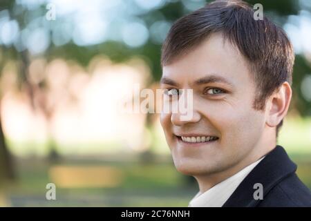 Attraente ritratto estivo di giovane uomo all'aperto, primo piano Foto Stock