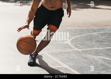 giovane uomo irriconoscibile che gioca a basket Foto Stock