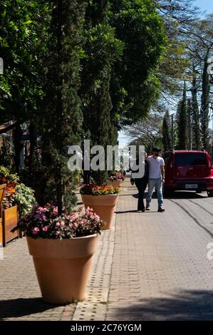 Marciapiede di via ciottoli Doria Vasconcelos, di fronte alla Casa Bela Cafe e ristorante all'aperto. Luogo decorato con fiori e piante verdi Foto Stock