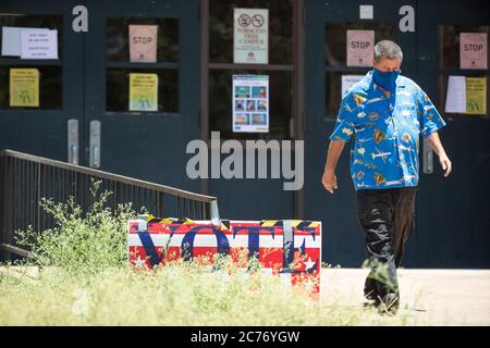 Austin, TX USA 14 luglio 2020: Gli elettori mascherati entrano nei seggi elettorali del sud di Austin per le elezioni primarie per determinare le matchup per le elezioni generali di novembre. Forte degli standard di deflusso, si prevede che il voto di persona sia ancora inferiore al 10% degli elettori registrati del Texas. Credit: Bob Daemmrich/Alamy Live News Foto Stock