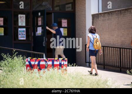 Austin, TX USA 14 luglio 2020: Gli elettori mascherati entrano nei seggi elettorali del sud di Austin per le elezioni primarie per determinare le matchup per le elezioni generali di novembre. Forte degli standard di deflusso, si prevede che il voto di persona sia ancora inferiore al 10% degli elettori registrati del Texas. Credit: Bob Daemmrich/Alamy Live News Foto Stock