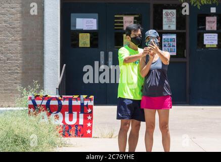 Austin, TX USA 14 luglio 2020: Gli elettori mascherati entrano nei seggi elettorali del sud di Austin per le elezioni primarie per determinare le matchup per le elezioni generali di novembre. Forte degli standard di deflusso, si prevede che il voto di persona sia ancora inferiore al 10% degli elettori registrati del Texas. Credit: Bob Daemmrich/Alamy Live News Foto Stock