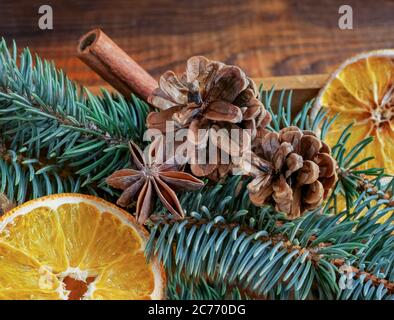 Composizione per le vacanze di Natale : bellissimi rami di abete rosso, di arance secche, bastoncini di cannella e di anice stellato, frutta secca, coni di abete in A. Foto Stock