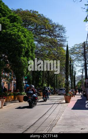 I motociclisti passano per via Doria Vasconcelos, proprio di fronte a Casa Bela - Cafe and Restaurant, nel centro di Holambra. Foto Stock