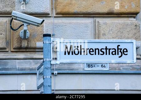 14 luglio 2020, Berlino, Berlino, Germania: Davanti ad una telecamera di sorveglianza si può vedere un cartello stradale modificato con l'iscrizione Moehrenstrasse (originariamente 'Mohrenstrasse'). Dagli anni '90 a Berlino si discute di una nuova denominazione della 'Mohrenstrasse' e della stazione della metropolitana omonima, nel contesto di un dibattito più ampio sui nomi delle strade che possono essere storicamente accusati. 'mohr' è un termine di discriminazione di lingua tedesca obsoleta per le persone di colore. Nel luglio 2020, la compagnia di trasporti pubblici di Berlino BVG ha deciso di rinominare la stazione della metropolitana "ohrenstraÃŸe". Il nuovo originale Foto Stock