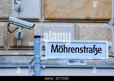 14 luglio 2020, Berlino, Berlino, Germania: Davanti ad una telecamera di sorveglianza si può vedere un cartello stradale modificato con l'iscrizione Moehrenstrasse (originariamente 'Mohrenstrasse'). Dagli anni '90 a Berlino si discute di una nuova denominazione della 'Mohrenstrasse' e della stazione della metropolitana omonima, nel contesto di un dibattito più ampio sui nomi delle strade che possono essere storicamente accusati. 'mohr' è un termine di discriminazione di lingua tedesca obsoleta per le persone di colore. Nel luglio 2020, la compagnia di trasporti pubblici di Berlino BVG ha deciso di rinominare la stazione della metropolitana "ohrenstraÃŸe". Il nuovo originale Foto Stock