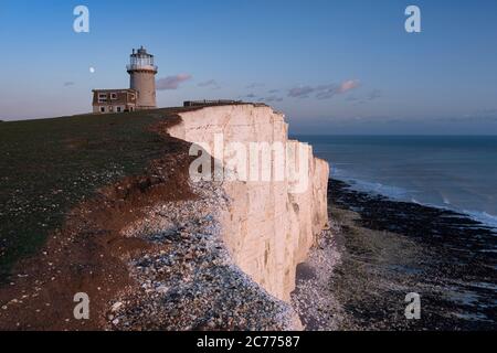 Moonrise sopra Belle Tout Lighthouse al tramonto, Beachy Head, vicino a Eastbourne, South Downs National Park, East Sussex, Inghilterra, Regno Unito Foto Stock