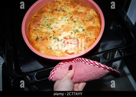 La cottura toglie una deliziosa torta calda dal forno Foto Stock