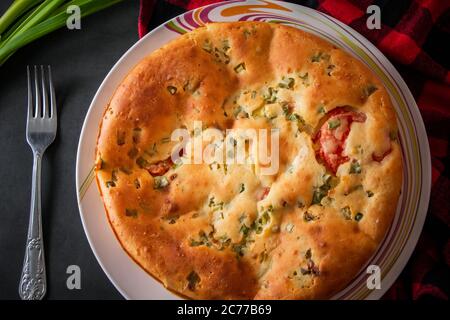 Deliziosa torta fatta in casa con pollo, erbe e pomodori su un piatto. Foto Stock