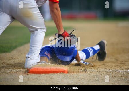 Un primo baseman da baseball contrassegna un secondo classificato di base in un gioco di ritiro in un'immagine ravvicinata con spazio per la copia nella parte superiore destra del telaio. Foto Stock