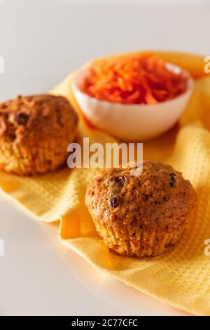 Appetitosi muffin di carote su sfondo bianco. Cucina alla moda, cottura a casa eco-friendly. Foto verticale Foto Stock