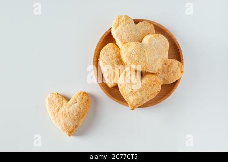 Biscotti di zucchero a forma di cuore su un piatto di legno. Simbolo di San Valentino, dolce regalo. Foto Stock