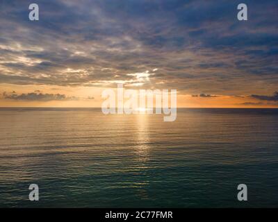 Vista aerea del drone tramonto sul mare con nuvola e luce solare con spazio copia. Foto Stock