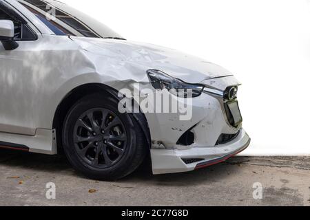 Parte anteriore della vettura di colore bianco danneggiata e rotta per incidente isolata su sfondo bianco. Foto Stock