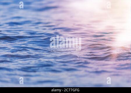 Vista ravvicinata dell'onda del mare con un'immagine sunrsie a basso angolo. Texture di sfondo per testo o disegno. Foto Stock