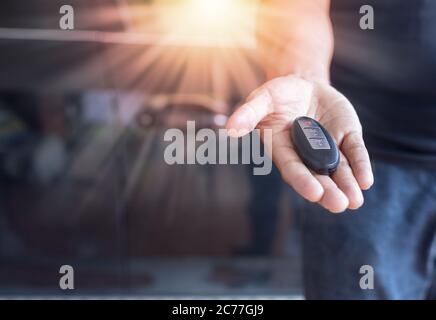Telecomando con chiave per auto a portata di mano. Mano uomo che dà un telecomando auto. Foto Stock