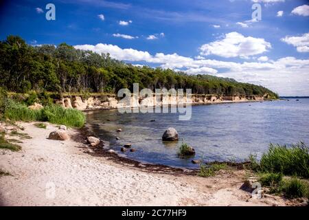 Timmendorf, Germania. 13 luglio 2020. Gli escursionisti si trovano sulla strada sotto la ripida costa dell'isola del Mar Baltico Poel vicino al porto di Timmendorf. Secondo il Ministero dell'ambiente di Schwerin, la ripida riva tra le città di Timmendorf e Hinter Wangern diminuisce di circa 55 metri in 100 anni senza protezione costiera. La sabbia, tuttavia, è lavata in su altrove, in modo da l'isola di Poel non diventerà più piccolo in termini di area. Credit: Jens Büttner/dpa-Zentralbild/ZB/dpa/Alamy Live News Foto Stock