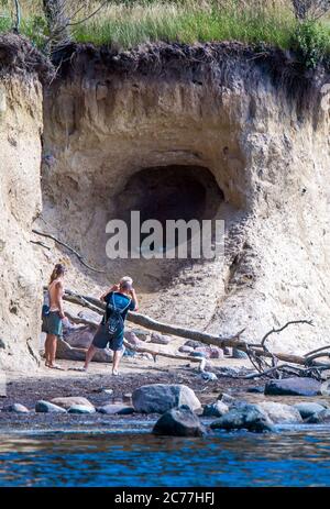 Timmendorf, Germania. 13 luglio 2020. Gli escursionisti si trovano sulla strada sotto la ripida costa dell'isola del Mar Baltico Poel vicino al porto di Timmendorf. Secondo il Ministero dell'ambiente di Schwerin, la ripida riva tra le città di Timmendorf e Hinter Wangern diminuisce di circa 55 metri in 100 anni senza protezione costiera. La sabbia, tuttavia, è lavata in su altrove, in modo da l'isola di Poel non diventerà più piccolo in termini di area. Credit: Jens Büttner/dpa-Zentralbild/ZB/dpa/Alamy Live News Foto Stock