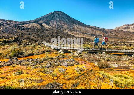 New Zealand escursione coppia Backpackers Tramping al Parco Nazionale di Tongariro. Escursionisti di sesso maschile e femminile a piedi dal Monte Ngauruhoe. Persone che vivono in salute Foto Stock