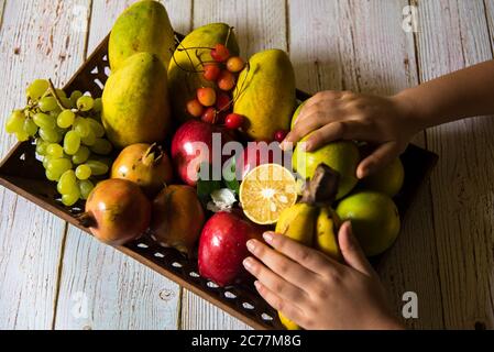 Vista dall'alto della frutta fresca con l'uso di una messa a fuoco selettiva su una frutta particolare, e il resto degli altri frutti e altre cose sfocati. Foto Stock