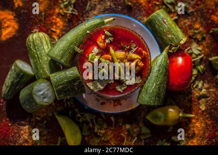 Primo piano della famosa Galka Nu Shaak di Gujarati su un piatto di vetro. Shot di spugna gourd piatto in un piatto di vetro insieme con tutte le spezie su un marrone con Foto Stock