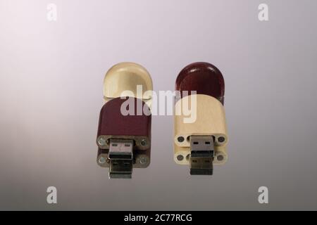 Due chiavette usb con cappuccio aperto realizzate con fondo grigio in legno Foto Stock