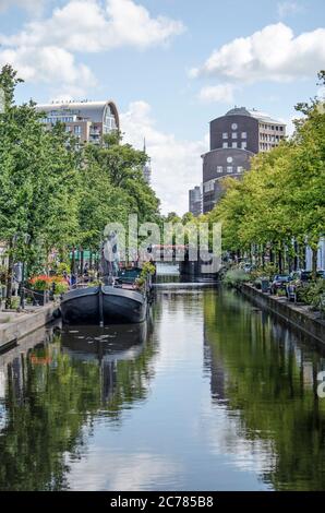 L'Aia, Paesi Bassi, 11 luglio 2020: Vista lungo il canale Zuid Singelsgracht con alberi, chiatte, automobili e edifici di appartamenti post-moderni Foto Stock