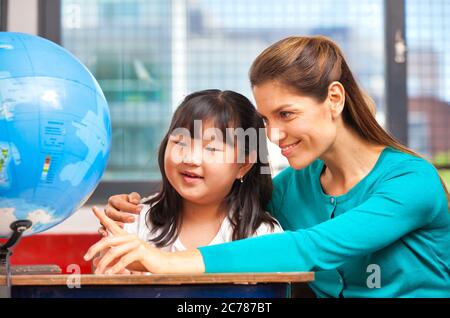 Scena scolastica elementare. Insegnante con alunni in classe. Foto Stock