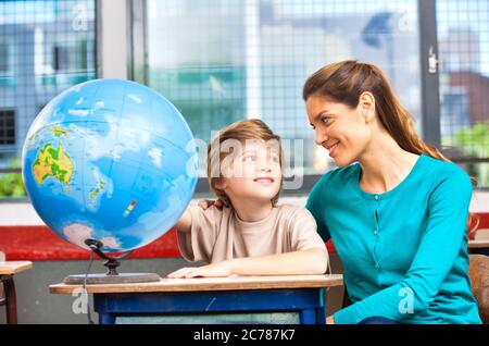 Scena scolastica elementare. Insegnante con alunni in classe. Foto Stock