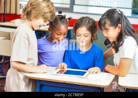 Scena scolastica elementare. I compagni di classe multietnici in classe imparano insieme. Concetto di ritorno a scuola Foto Stock