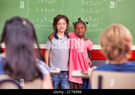 Scena scolastica elementare. Felici amici multietnici. Foto Stock