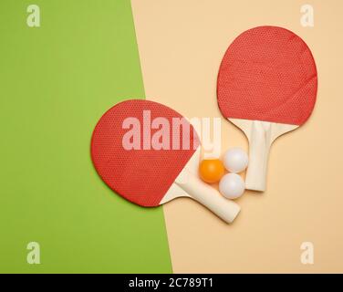 due racchette in legno e una palla di plastica arancione per giocare a ping pong, piatto Foto Stock