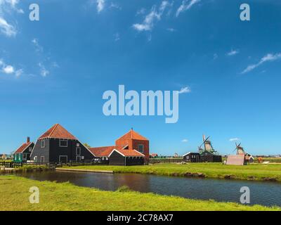 Tradizionale fattoria olandese in legno presso il museo Zaanse Schans con acqua di fronte Foto Stock