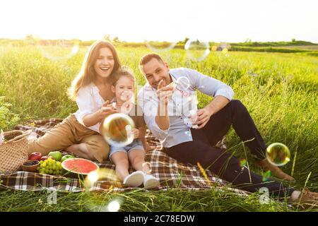 Buona famiglia che gioca insieme in un picnic in prato Foto Stock