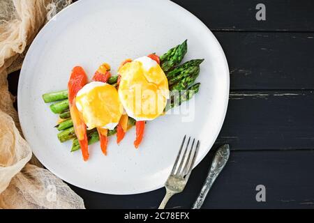 Uovo in camicia con salsa di hollandaise e salmone su asparagi Foto Stock