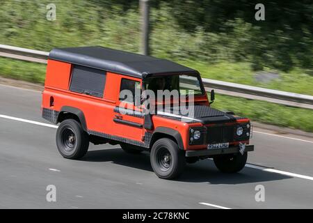 Un 110 Land Rover 1997 Defender TDI Orange LCV Hardtop Van Diesel guida sull'autostrada M6 vicino Preston a Lancashire, Regno Unito Foto Stock