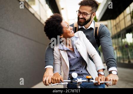 Gente allegra che va per un giro in bicicletta. Buona coppia divertirsi in città. Foto Stock