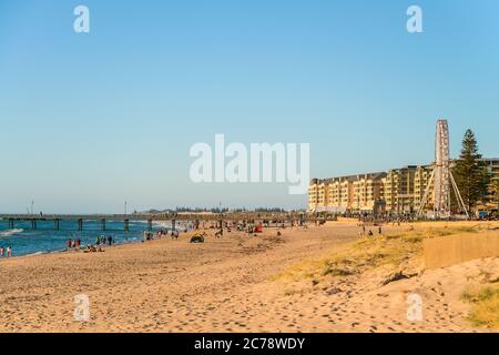 Adelaide, Australia del Sud - 12 gennaio 2019: Persone che trascorrono del tempo a Glenelg Beach con l'iconica ruota panoramica nelle vicinanze in una giornata estiva luminosa Foto Stock